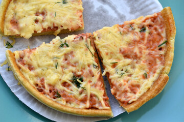 Cheap little pizza with cheese close-up on a plate