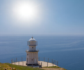 Fototapeta na wymiar lighthouse on a marine cape at the summer sunny day