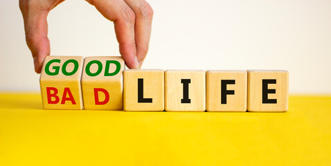 Good life concept for fresh start, new year resolution, dieting and healthy lifestyle. Businessman turns cubes and changes words 'bad life' to 'good life'. Beautiful white background, copy space.