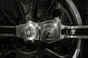 Black steel wheel from vintage train steam locomotive with connecting rods and fastener nuts nobody