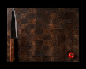 Handmade wooden chopping board with fresh vegetables on a dark background. space for labels