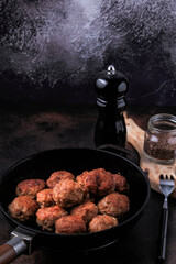 Easy Homemade Meatballs in a frying pan on dark background.  
