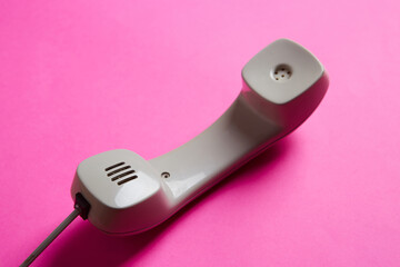 top view closeup of speaker vintage telephone on a pink background