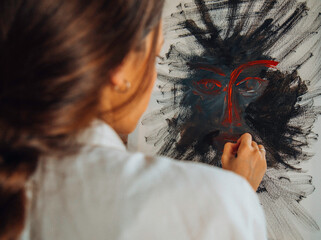 Beautiful talented female artist painting at her home.