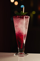 cocktail with ice in glass on the dark background
