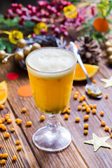 the hot yellow drink with sea-buckthorn berries in a glass