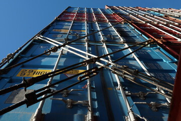 Stack of  different colors containers secured on the ship and lashes with lashing bars, turnbuckles...