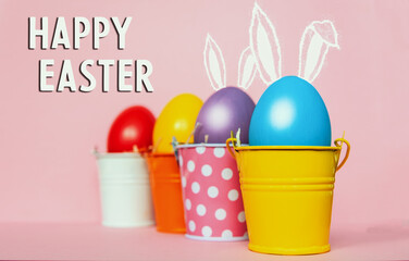 colored Easter eggs in bright buckets with bunny rabbit ears,   selective focus image. Happy Easter card.	
