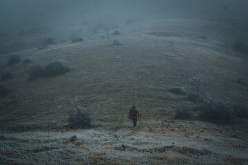 A backpacker traveler trying to find his way through the fog.