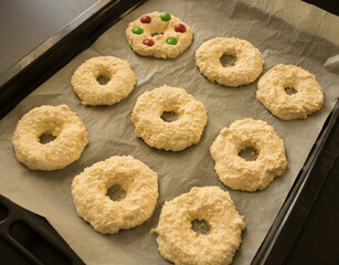 Cottage cheese rings on a baking paper on a baking sheet. Receip for breakfast. Selective focus