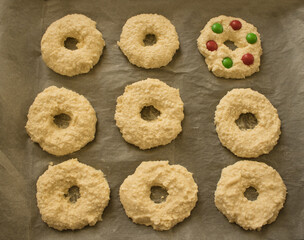 Cottage cheese rings on a baking paper on a baking sheet. Receip for breakfast. Selective focus
