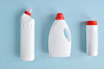 White detergent bottles on a blue background. Flat lay