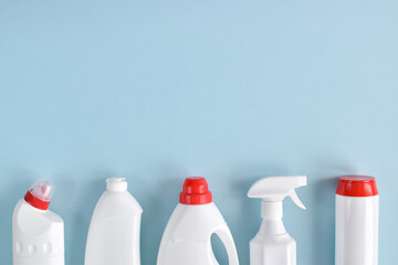 White detergent bottles on a blue background. Flat lay