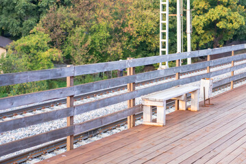 Fototapeta premium Bench on the railway platform. Wooden platform, bench and fence during station renovation