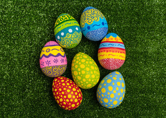 Colorful hand painted Easter eggs on green grass background. Easter decoration