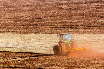 Tractor plowing land to plant sugar cane