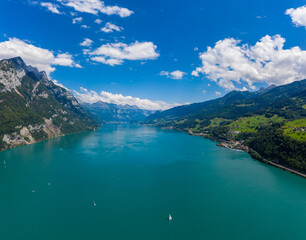 Fototapeta na wymiar Aerial drone shot over beautiful Walensee lake, Switzerland, with boats and yacht sailing through turquoise waters 