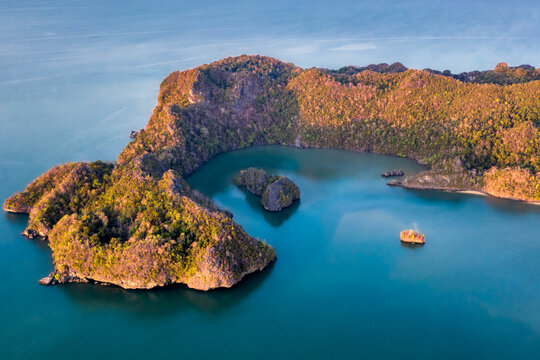 Langkawi Malaysia aerial ocean cove during the morning golden hours. Soft blue ocean waters and several islands protected by the forested peninsula