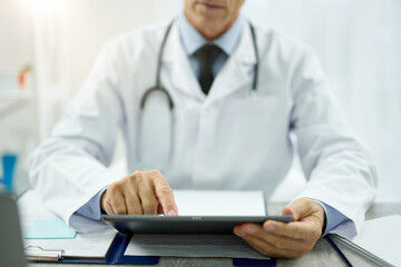 Male doctor using tablet computer at work