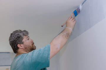 Close up of painter hands with painting the wall edge with brush