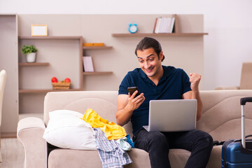 Young man preparing for journey at home