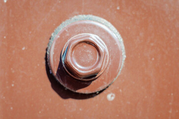 A metal fence and a self-tapping screw screwed into it.