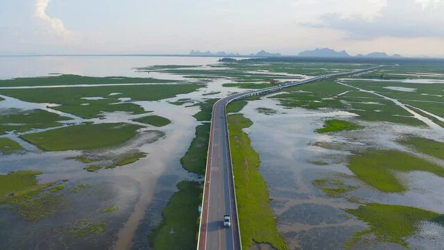 Aerial view of street road highway with swamp or lagoon in Phang Nga Bay, lake, sea or river in national park and mountain or hill in Thailand. Natural landscape background.