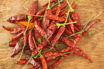chili red with green stalk dried pepper pods on wooden background