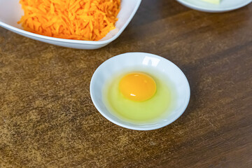 yolk in a bowl on a background of grated carrots carrot cake recipe