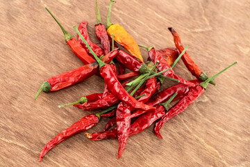 scattering of red and yellow chili peppers on wooden background close-up