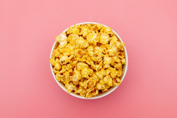 Caramel of pop icons in multicolored cups on pink background