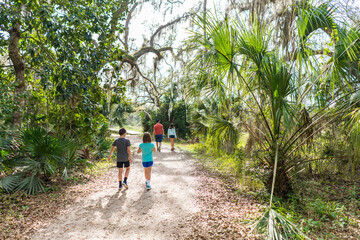 Family hiking outdoors on a path in Florida © Sarah Rypma
