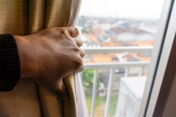 the left hand opens the window curtain from right to left