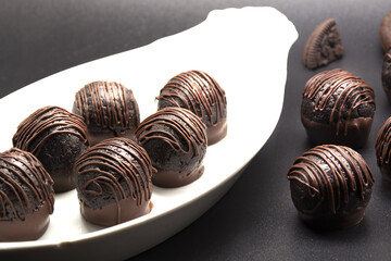 chocolate candy truffles in white plate. Homemade dark chocolate truffles. Delicious chocolate dessert.
