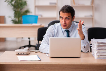 Obraz premium Young male employee unhappy with excessive work