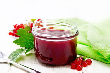 Jam of red currant in jar on light board