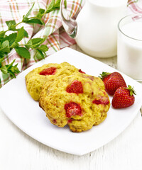 Scones with strawberry in plate on board