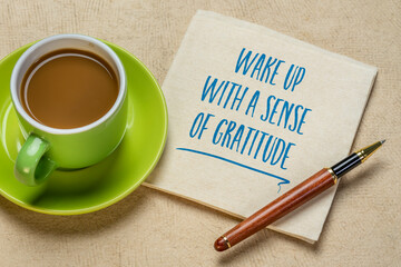 wake up with a sense of gratitude inspirational handwriting on a napkin with a cup of coffee, positivity and personal development concept