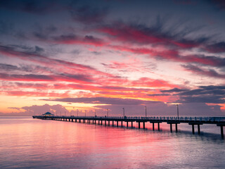 Fototapeta na wymiar Beautiful Seaside Sunrise with Dramatic Sky and Pier