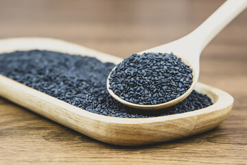 Black sesame seeds in a wooden spoon For healthy food and diet concepts.