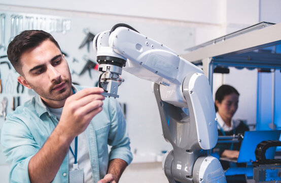 Male Engineers Maintenance Robot Arm at Lab. he are in a High Tech Research Laboratory with Modern Equipment. Technology and Innovation Concept.Professional.