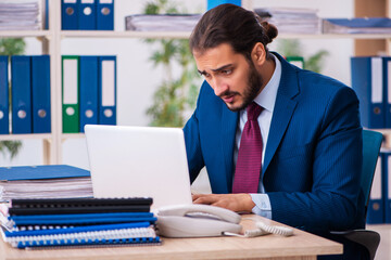 Fototapeta premium Young male employee and too many work in the office