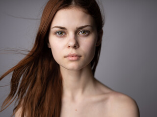 Naklejka premium portrait of a beautiful woman close-up red hair gray background Mode