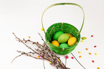 Easter background, colorful easter eggs and decorations next to baskets and pussy willow branches