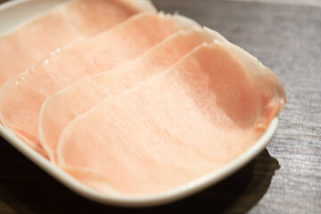 Sliced pork on white plate served for Sukiyaki and Shabu.