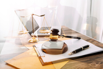 Justice and law concept.Male judge in a courtroom with the gavel, working with, computer and docking keyboard, eyeglasses, on table in morning light