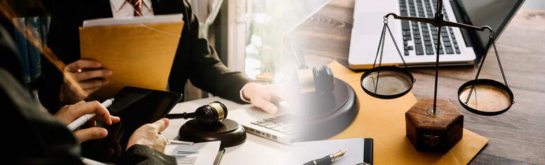 Justice and law concept.Male judge in a courtroom with the gavel, working with, computer and docking keyboard, eyeglasses, on table in morning light