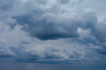 Dark blue grey cloudy sky with fluffy clouds
