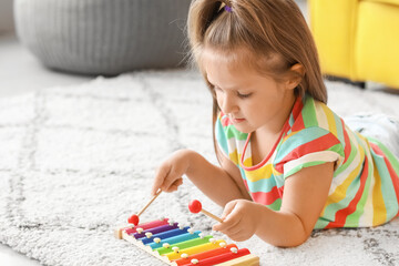 Cute little girl with xylophone at home