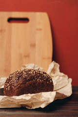 rye bread on a wooden table paper packaging sharp knife red background board